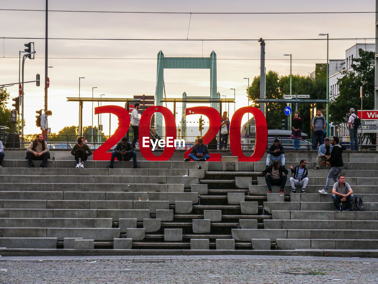 People on steps against sky in city during sunset