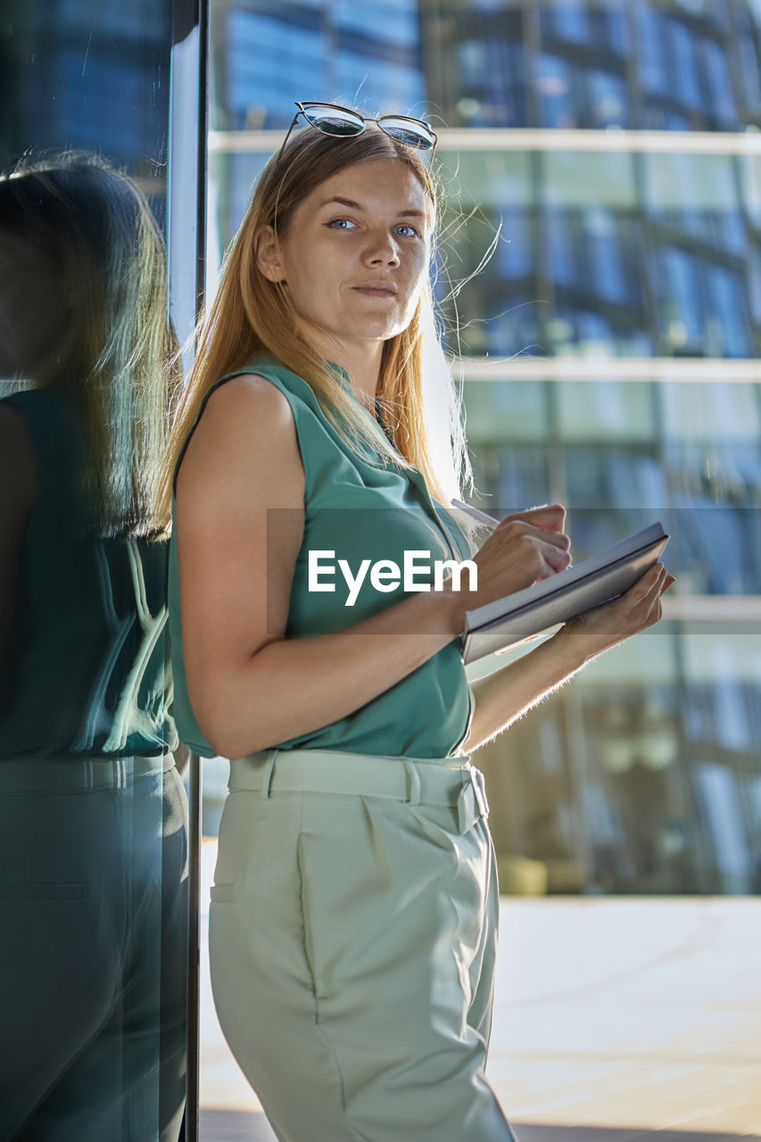 Side view of young woman looking at glass window