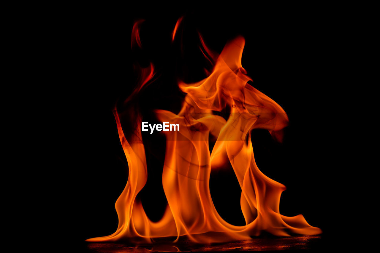 CLOSE-UP OF RED BURNING AGAINST BLACK BACKGROUND