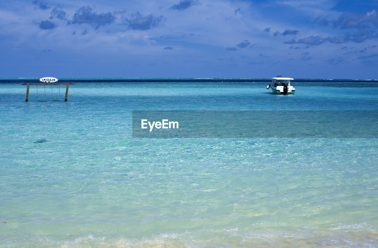 water, sea, sky, horizon, ocean, land, beauty in nature, scenics - nature, shore, beach, nature, tranquility, horizon over water, travel, travel destinations, tranquil scene, blue, vacation, trip, body of water, cloud, holiday, lagoon, coast, idyllic, transportation, nautical vessel, tourism, bay, no people, day, mode of transportation, outdoors, island, tropical climate, turquoise colored, environment, seascape, summer, wave, wind wave, sand, non-urban scene, relaxation, sunlight, islet, landscape, coastline, tourist resort, architecture, sunny