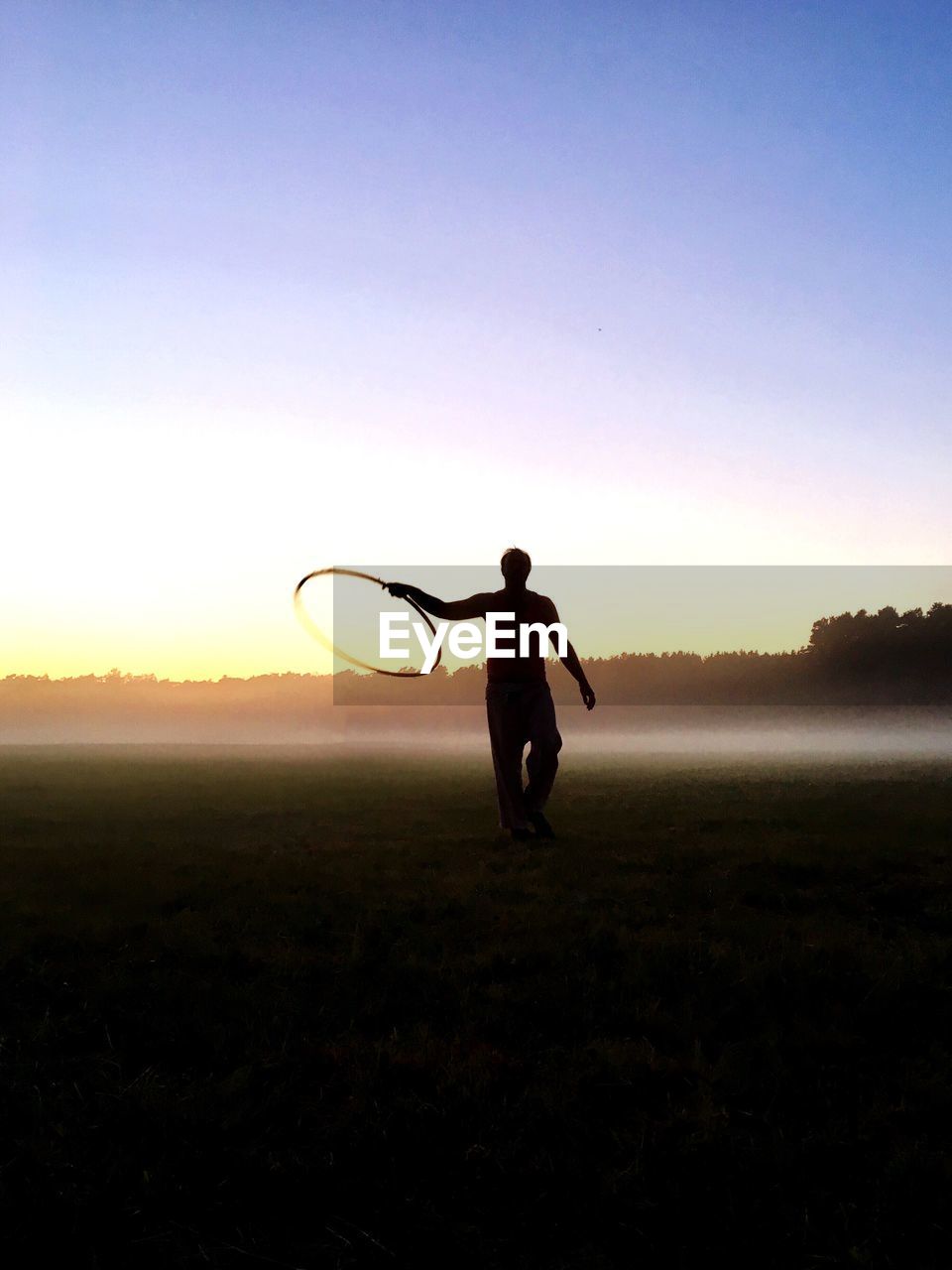 Silhouette of man playing outdoors