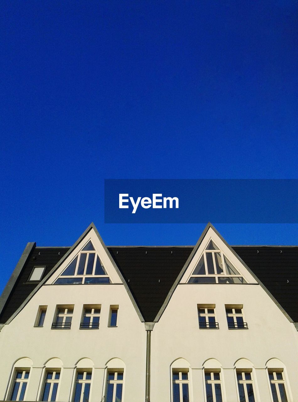 LOW ANGLE VIEW OF BUILDINGS AGAINST CLEAR BLUE SKY