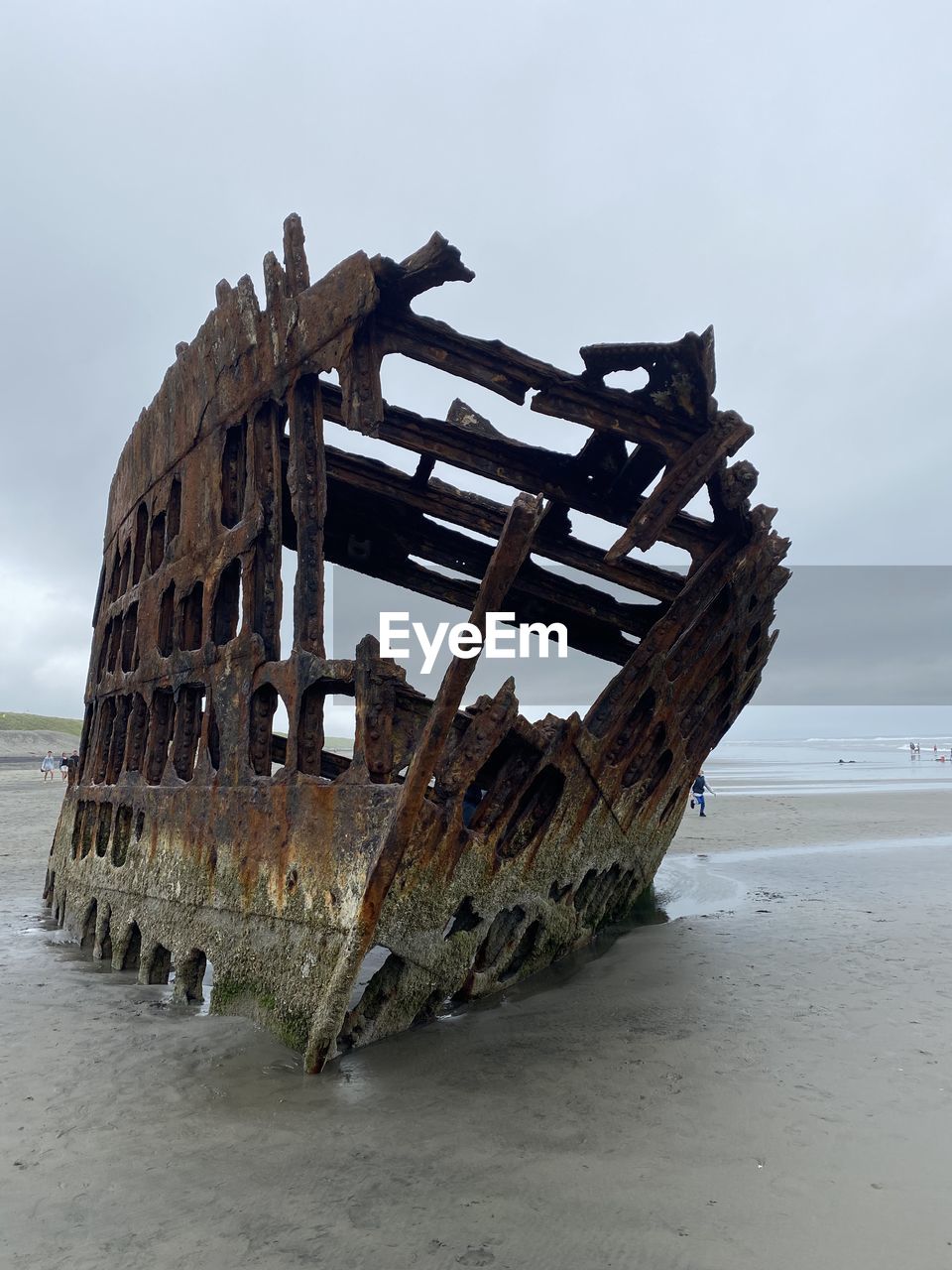 Abandoned ship on beach against sky