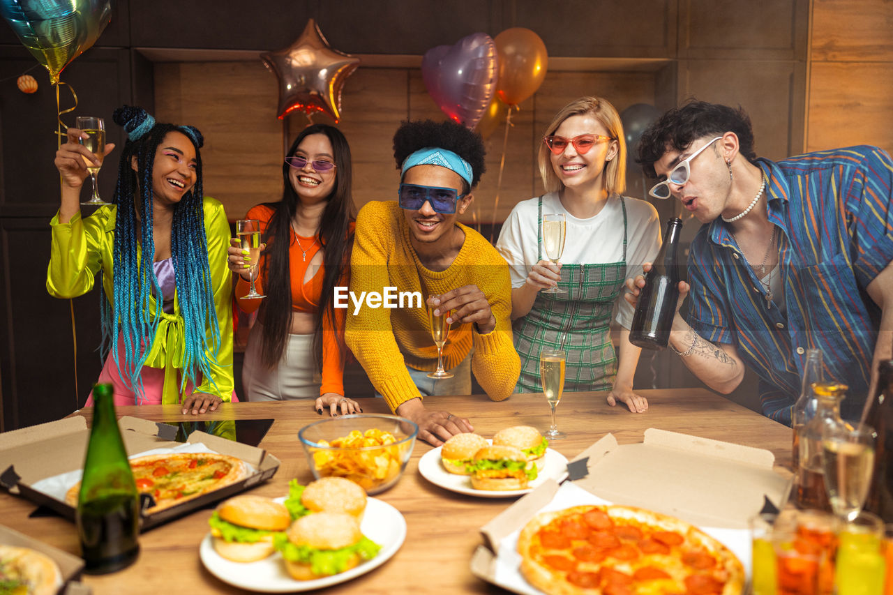 portrait of smiling friends with food on table