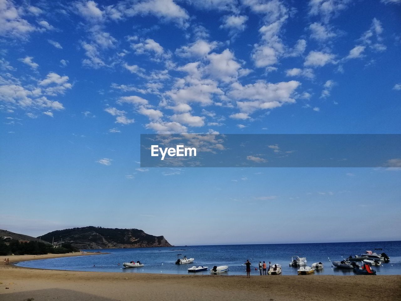 PEOPLE AT BEACH AGAINST BLUE SKY