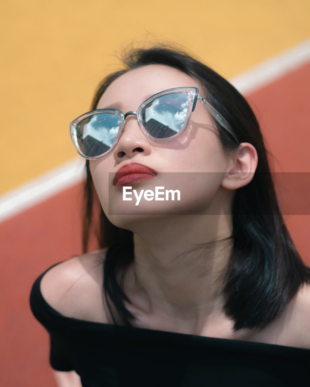 CLOSE-UP OF YOUNG WOMAN WITH SUNGLASSES