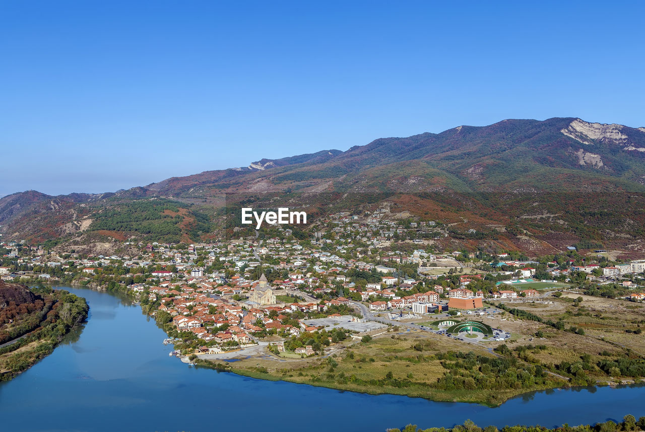 AERIAL VIEW OF LAKE BY BUILDINGS AGAINST BLUE SKY