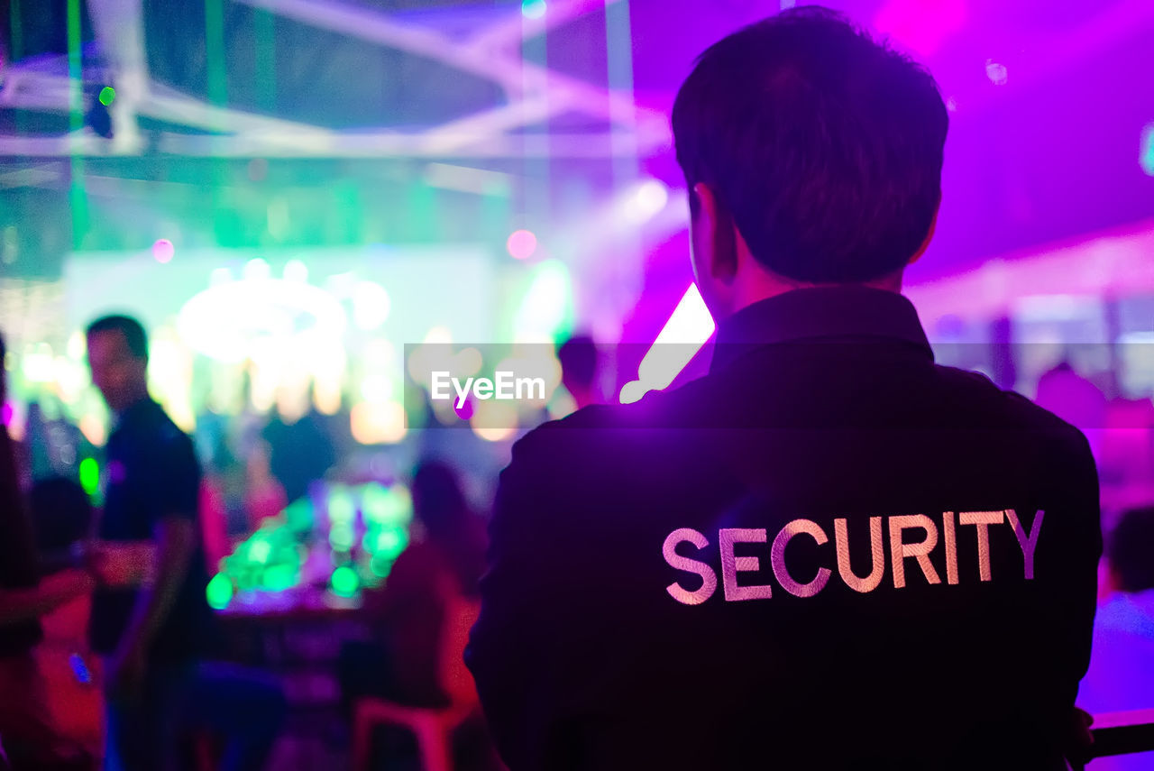 Rear view of security guard at music concert