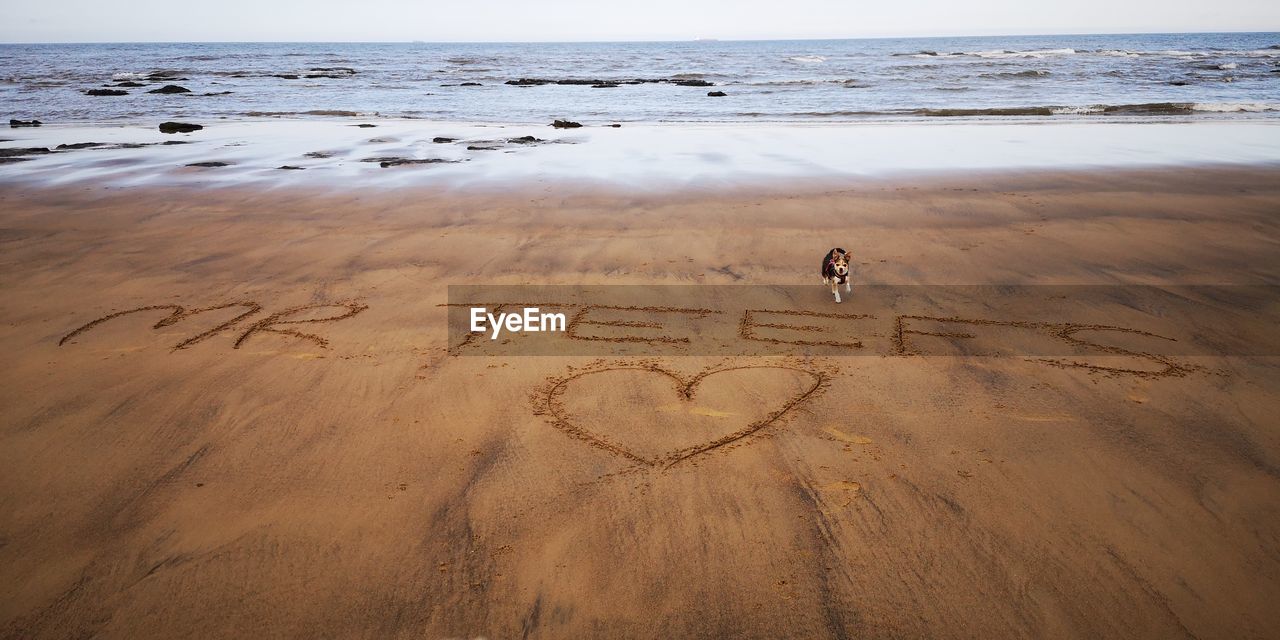 HIGH ANGLE VIEW OF HEART SHAPE ON SHORE