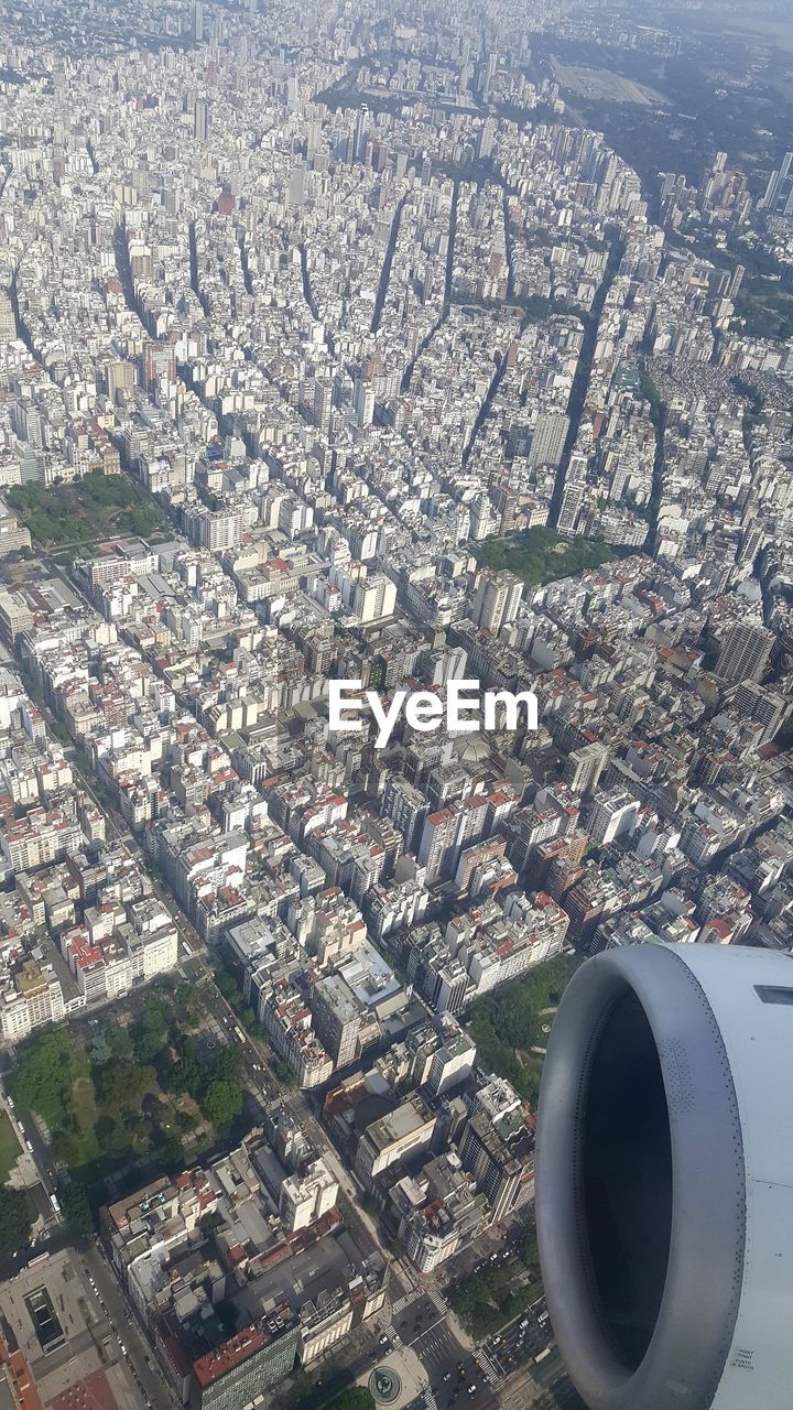 HIGH ANGLE VIEW OF AIRPLANE WING OVER CITYSCAPE