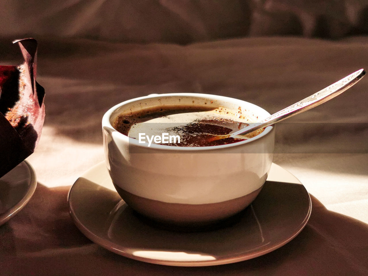 CLOSE-UP OF COFFEE CUP ON TABLE AGAINST BLACK BACKGROUND