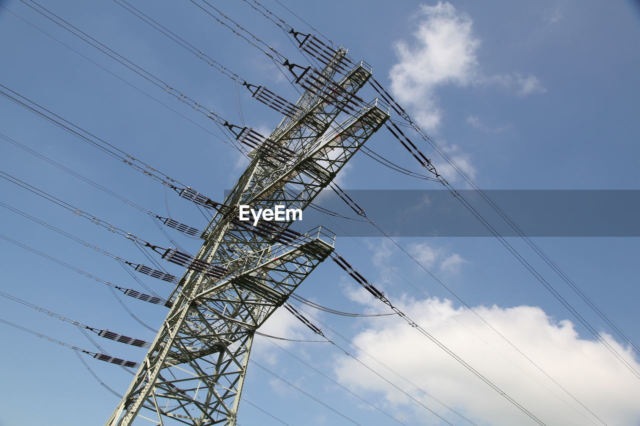 Low angle view of electricity pylon against blue sky