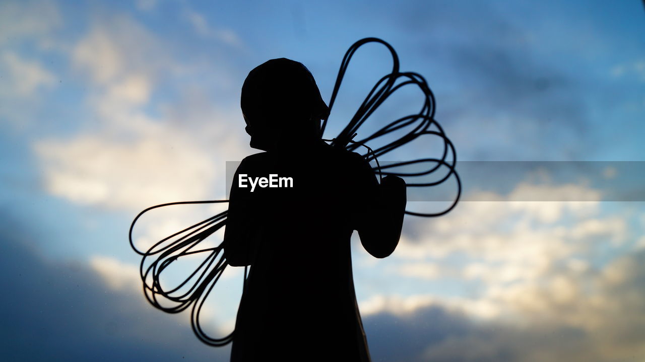 Silhouette toy against sky during sunset