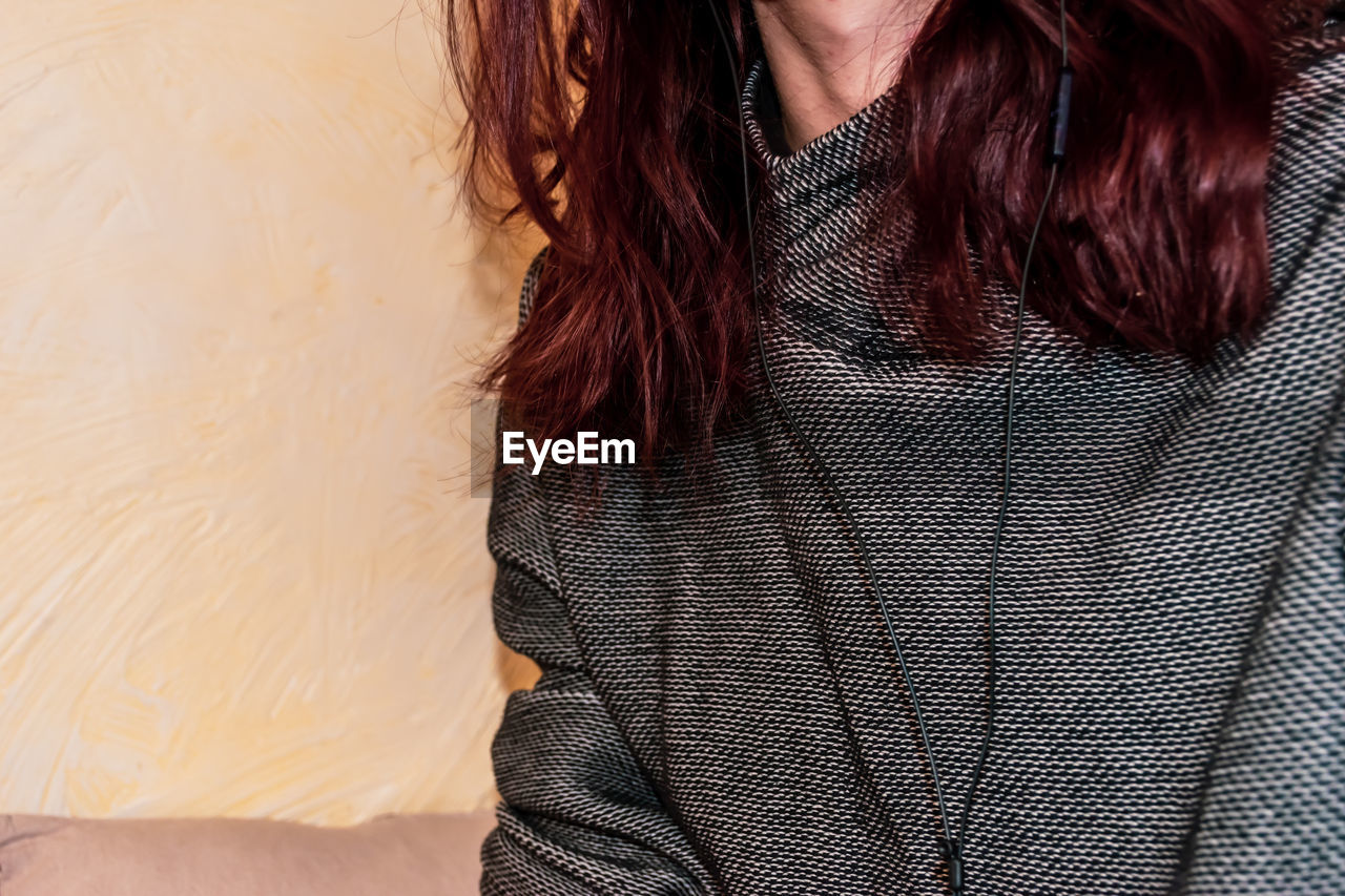 Midsection of woman with in-ear headphones