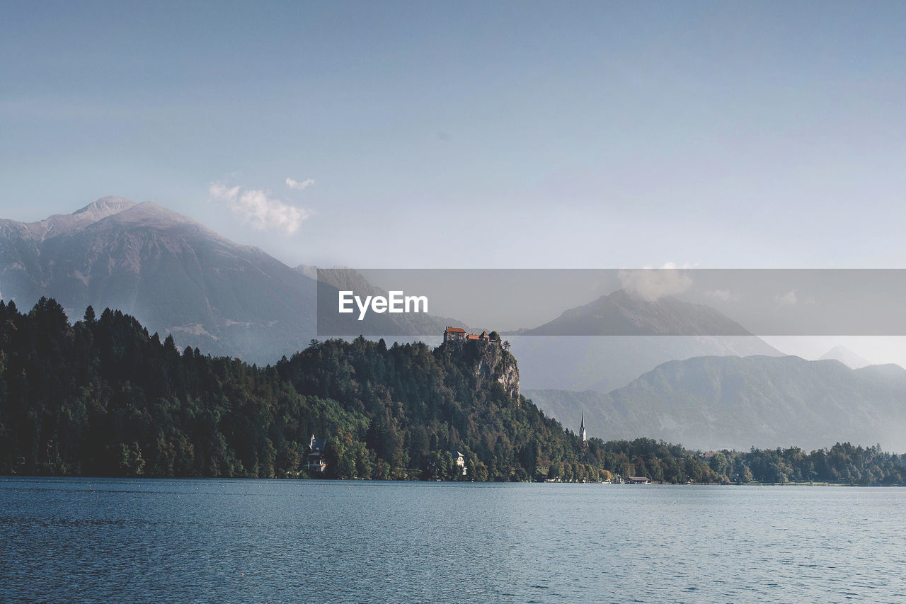 Scenic view of river by mountains against sky