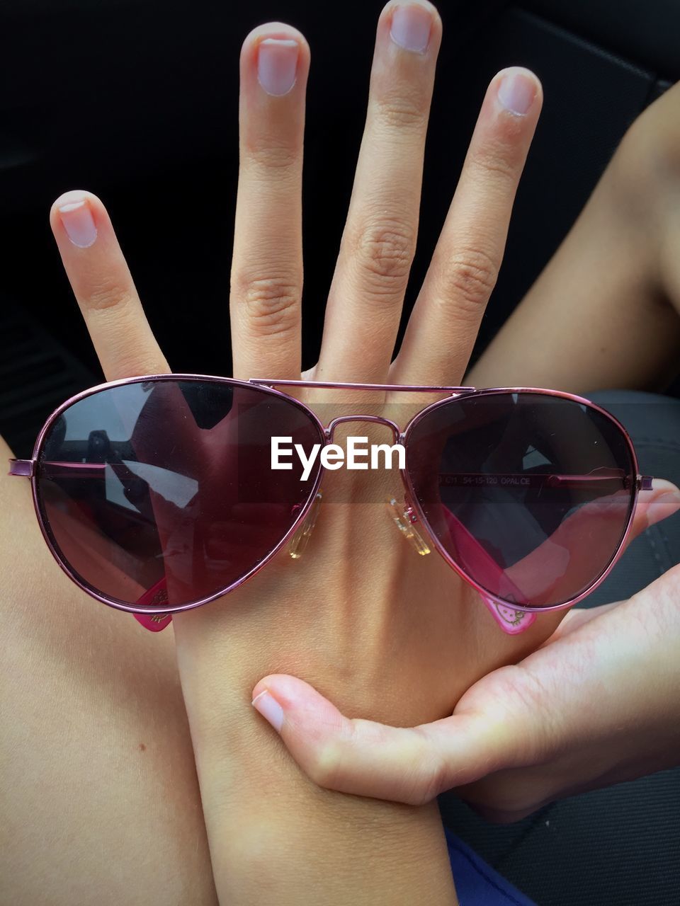 CLOSE-UP OF WOMAN HAND HOLDING SUNGLASSES