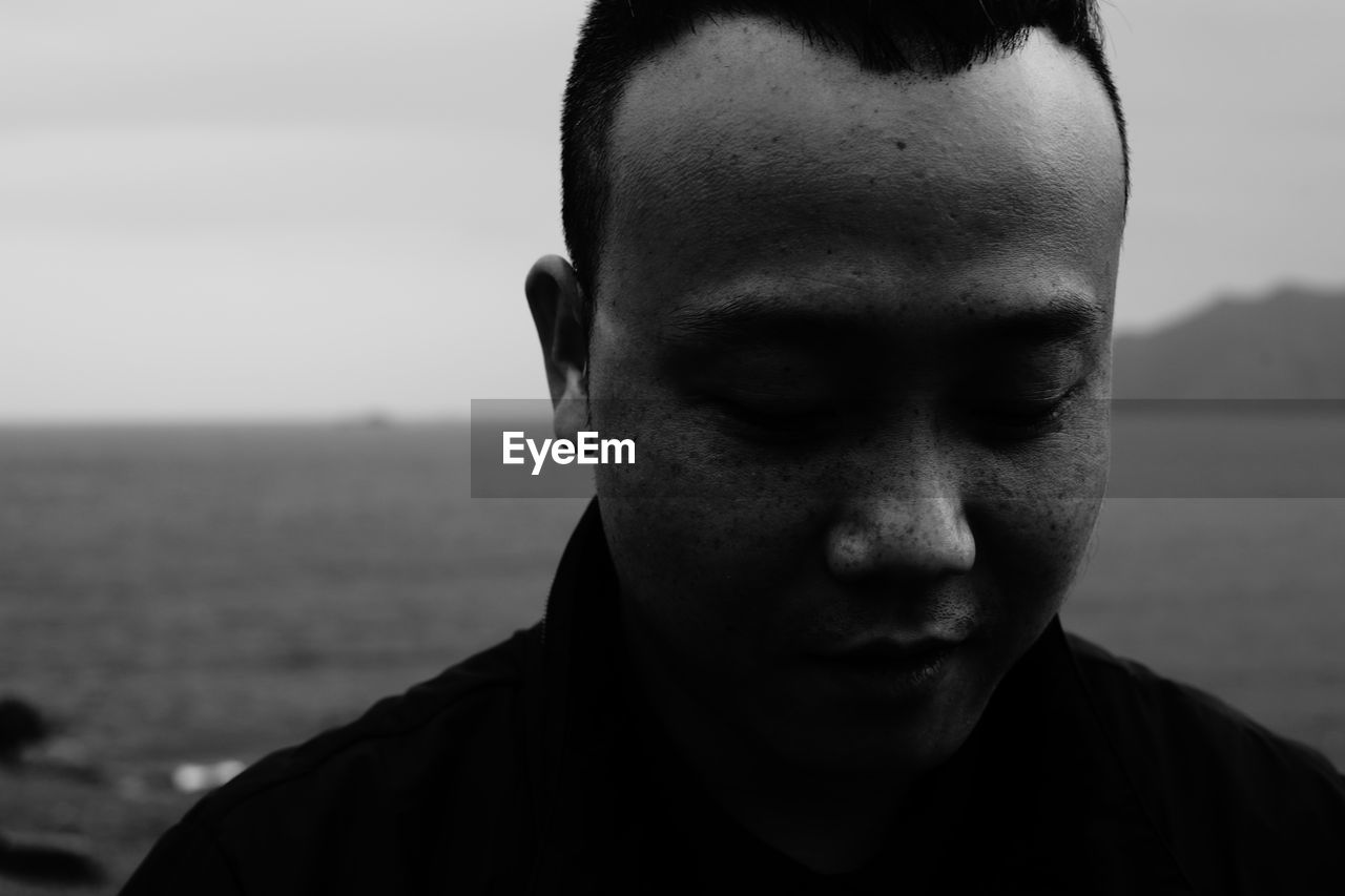 Portrait of young man against sea