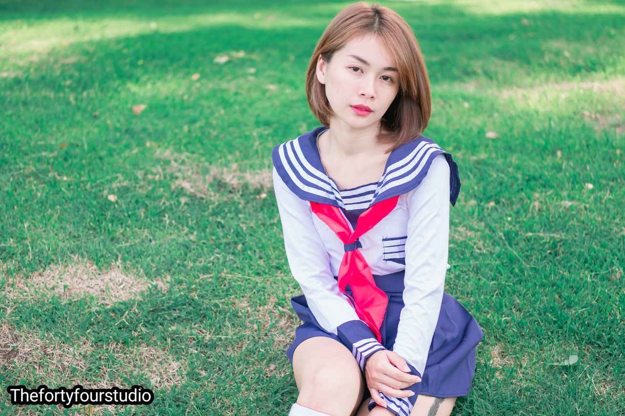 WOMAN SITTING ON FIELD