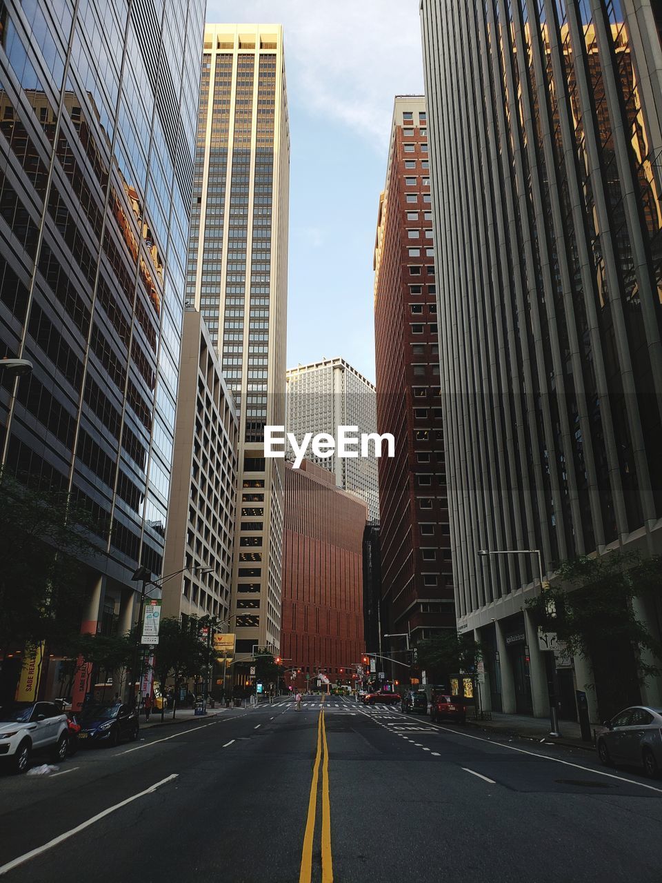 Road amidst buildings in city against sky