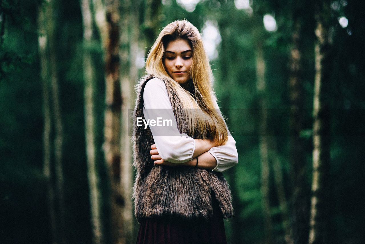 PORTRAIT OF YOUNG WOMAN STANDING OUTDOORS