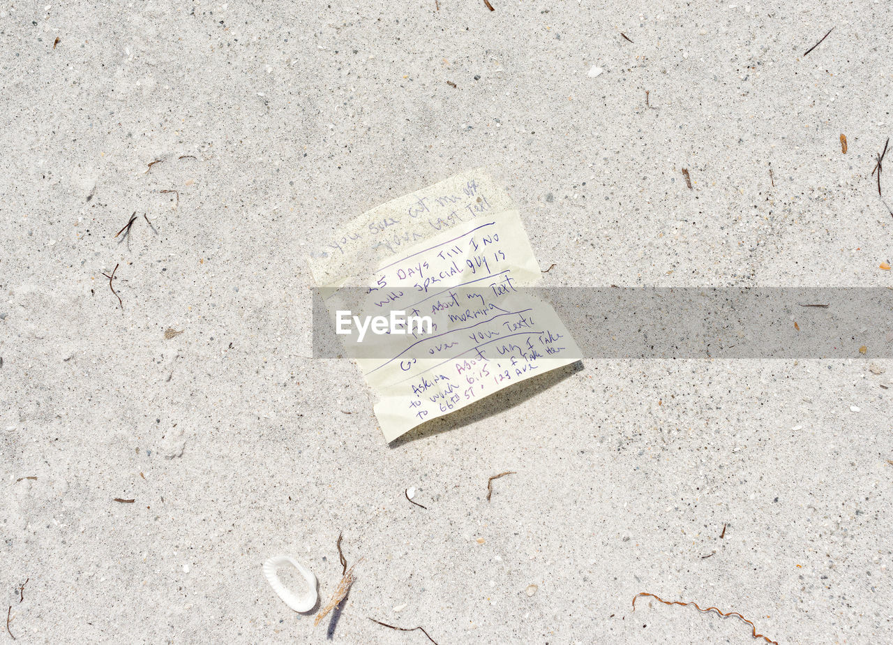 CLOSE-UP OF TEXT ON SAND AT BEACH