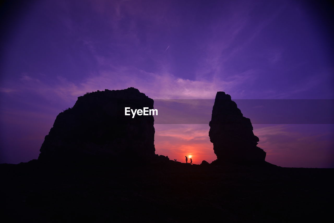 Low angle view of silhouette rock formation against sky during sunset