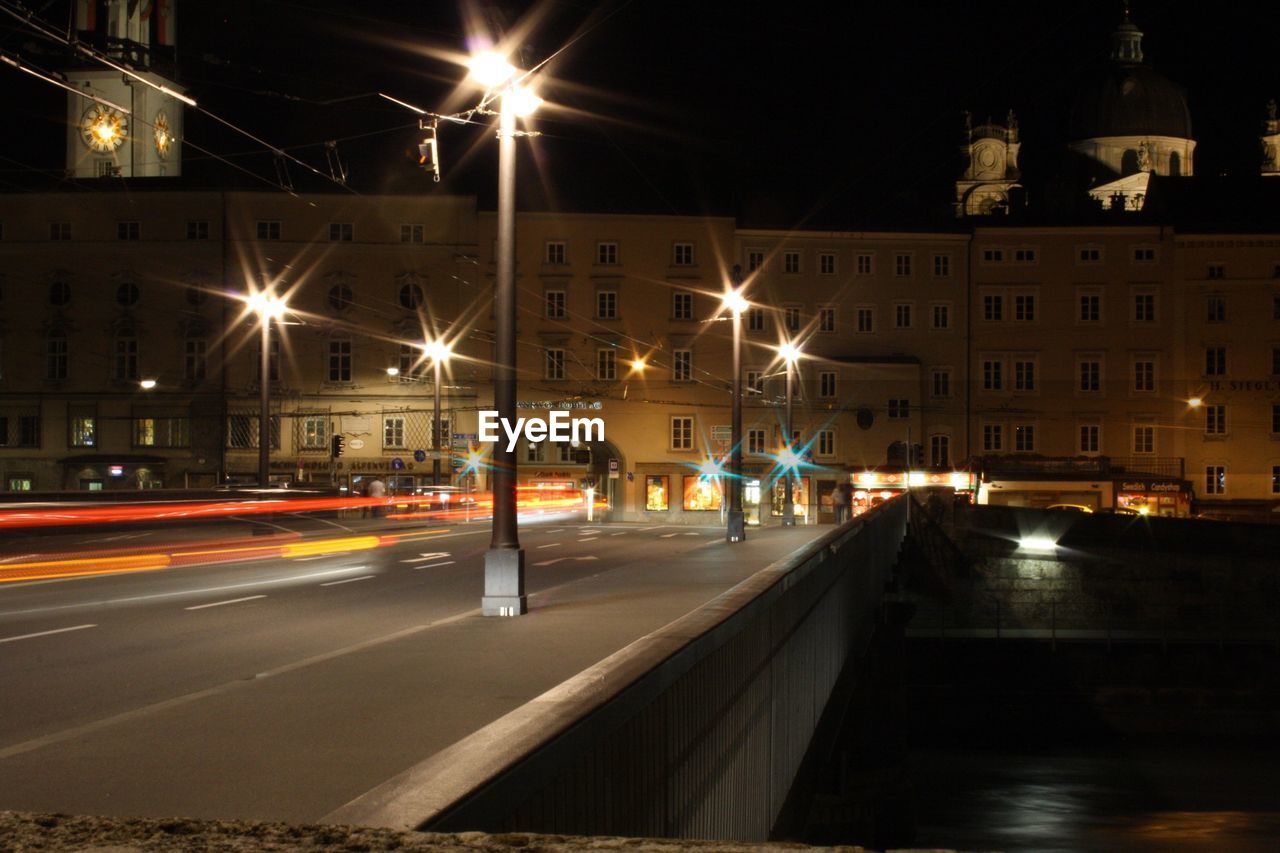 Light trails on illuminated street at night