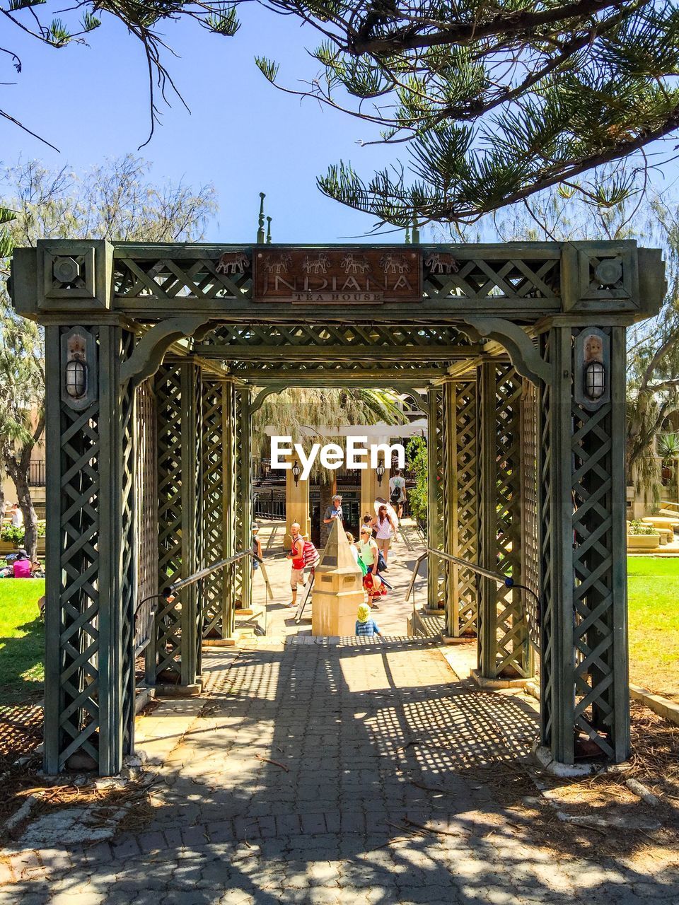 Metal structure at entrance on garden against clear sky