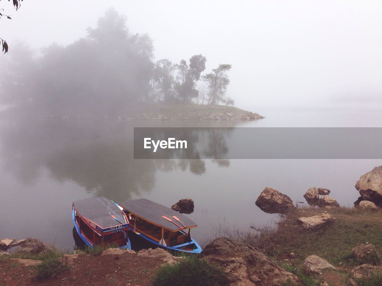 Scenic view of lake against sky during foggy weather