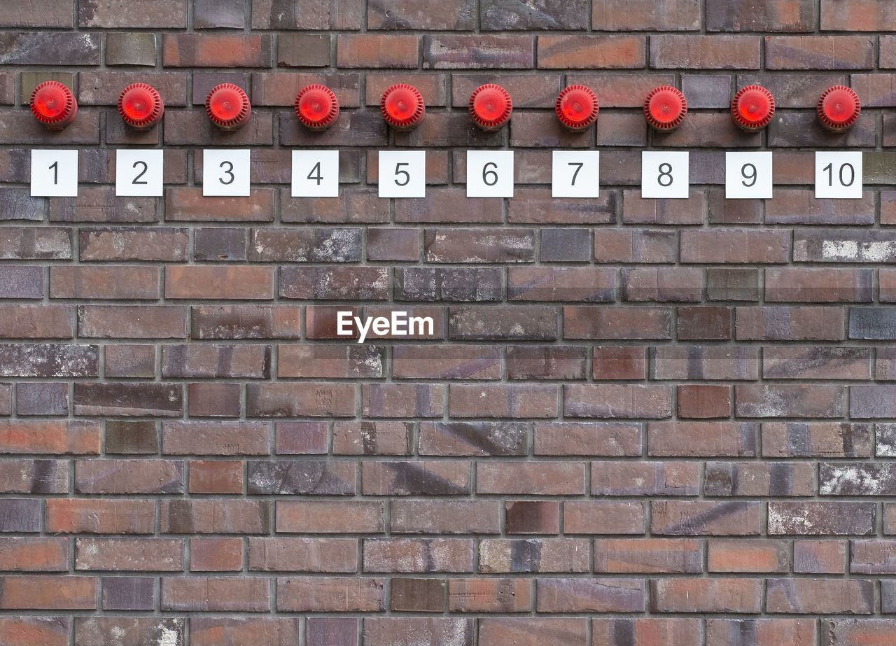 Red lights with numbers on brick wall