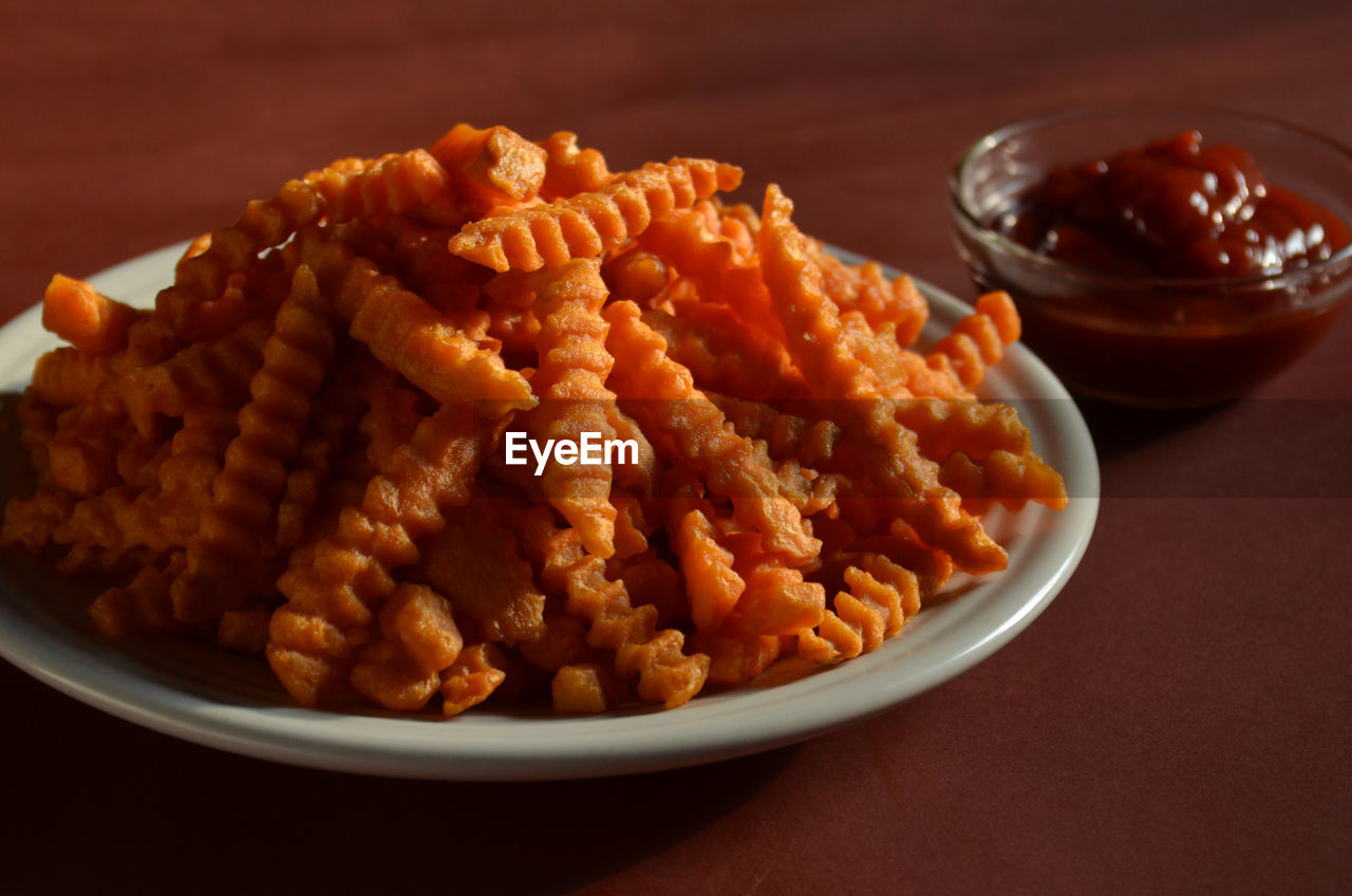 Close-up of sweet potato french fries with ketchup on table