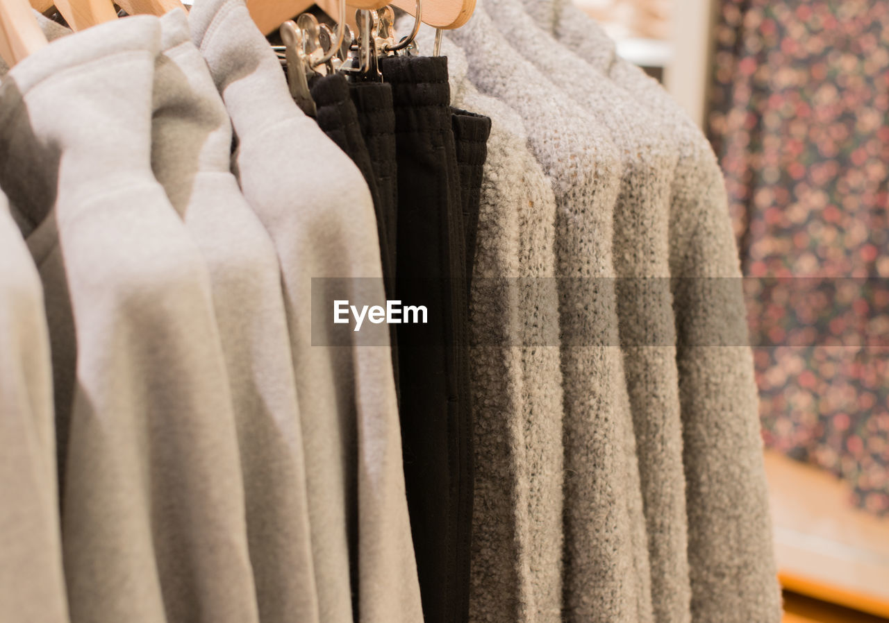 CLOSE-UP OF CLOTHES HANGING ON DISPLAY STORE