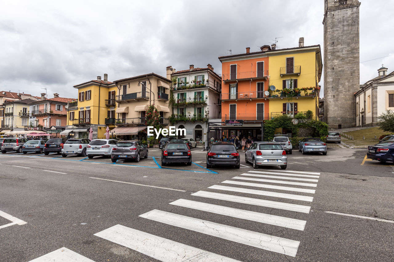 VEHICLES ON ROAD ALONG BUILDINGS