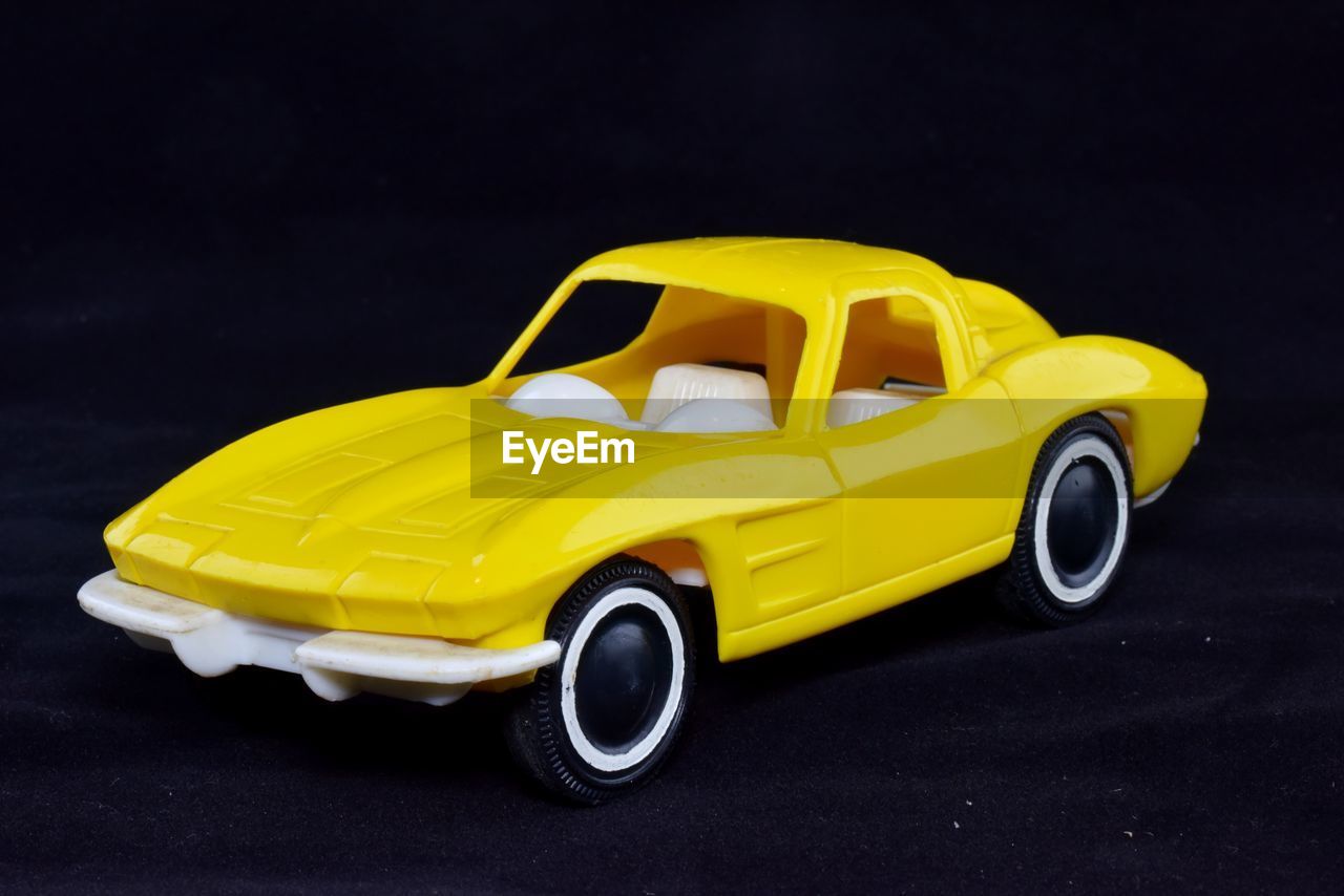 Close-up of yellow toy car on black background