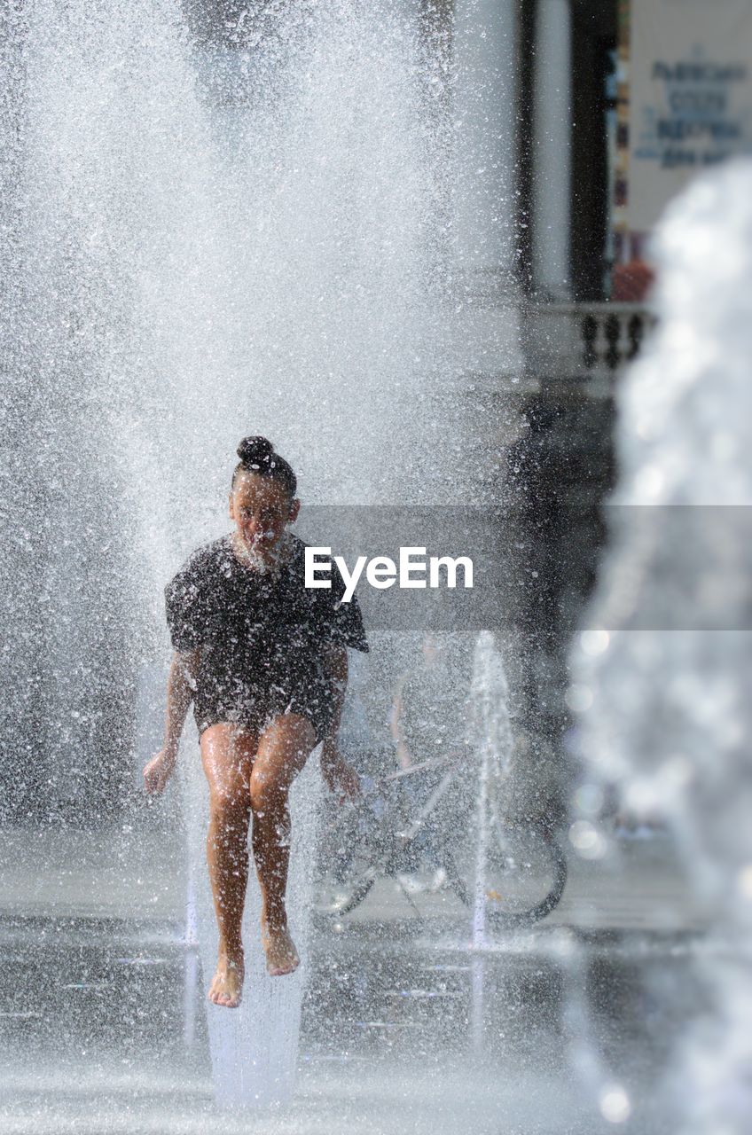 MAN SPLASHING WATER IN CITY