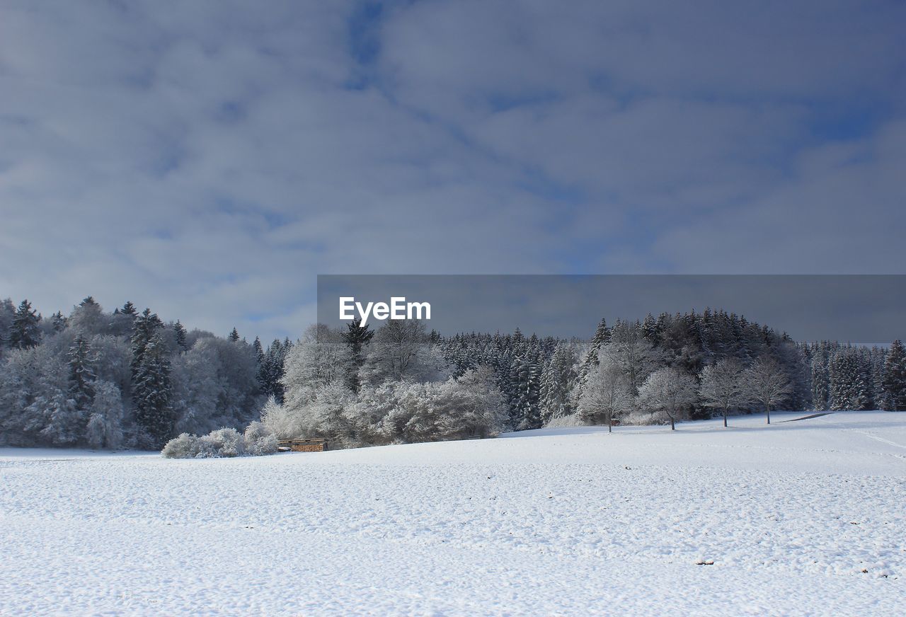 Snow covered field against sky