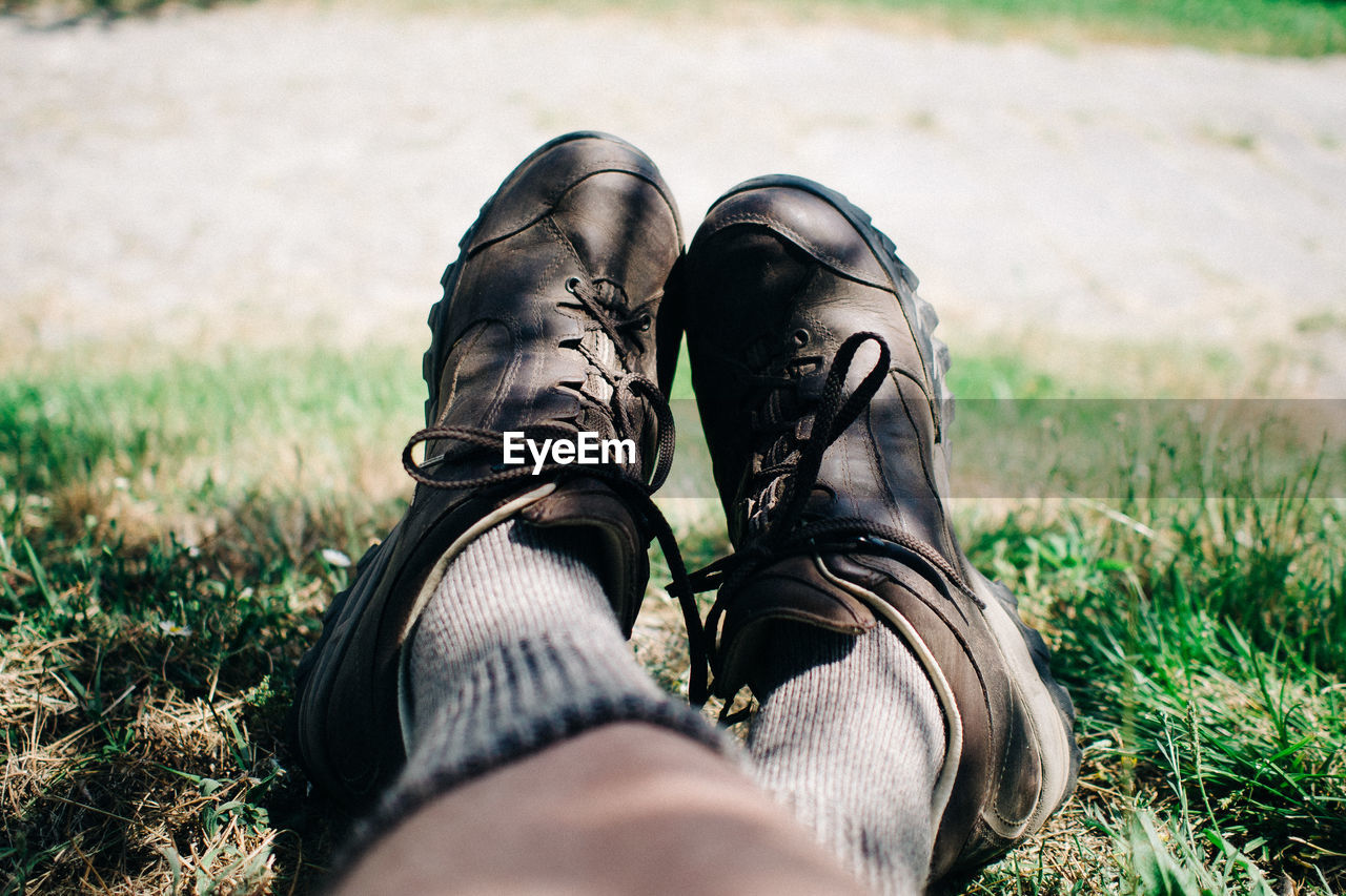 Low section of man resting on grassy field