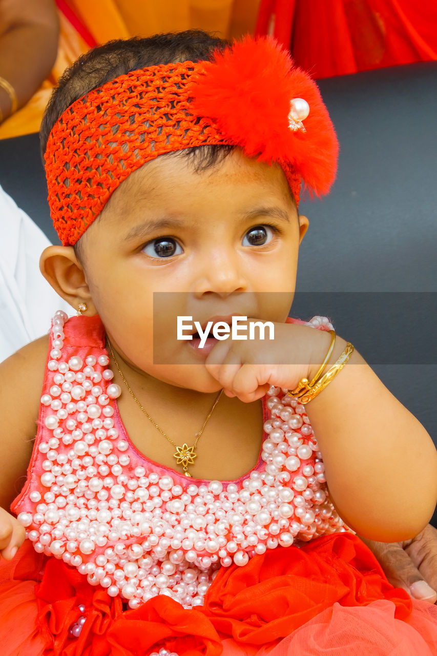 child, childhood, portrait, baby, clothing, cute, one person, looking at camera, person, innocence, toddler, front view, women, emotion, female, red, baby clothing, fashion accessory, indoors, hat, skin, human face, babyhood, smiling, sitting, happiness, lifestyles, headshot, pink, close-up