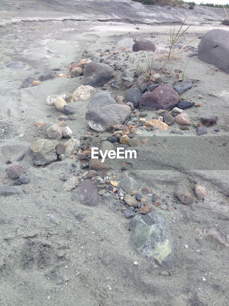 HIGH ANGLE VIEW OF PEBBLES ON BEACH