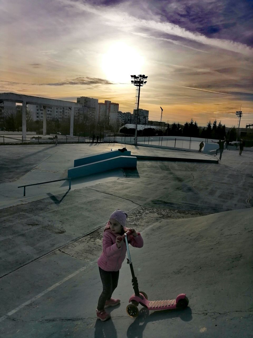 Full length of girl with push scooter against sky during sunset