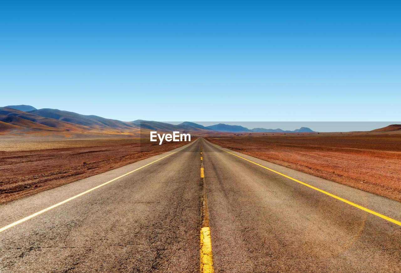 Road amidst desert against clear sky