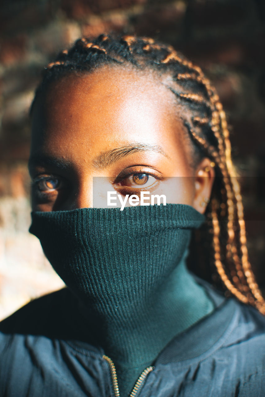 CLOSE-UP PORTRAIT OF YOUNG WOMAN COVERING FACE WITH EYES