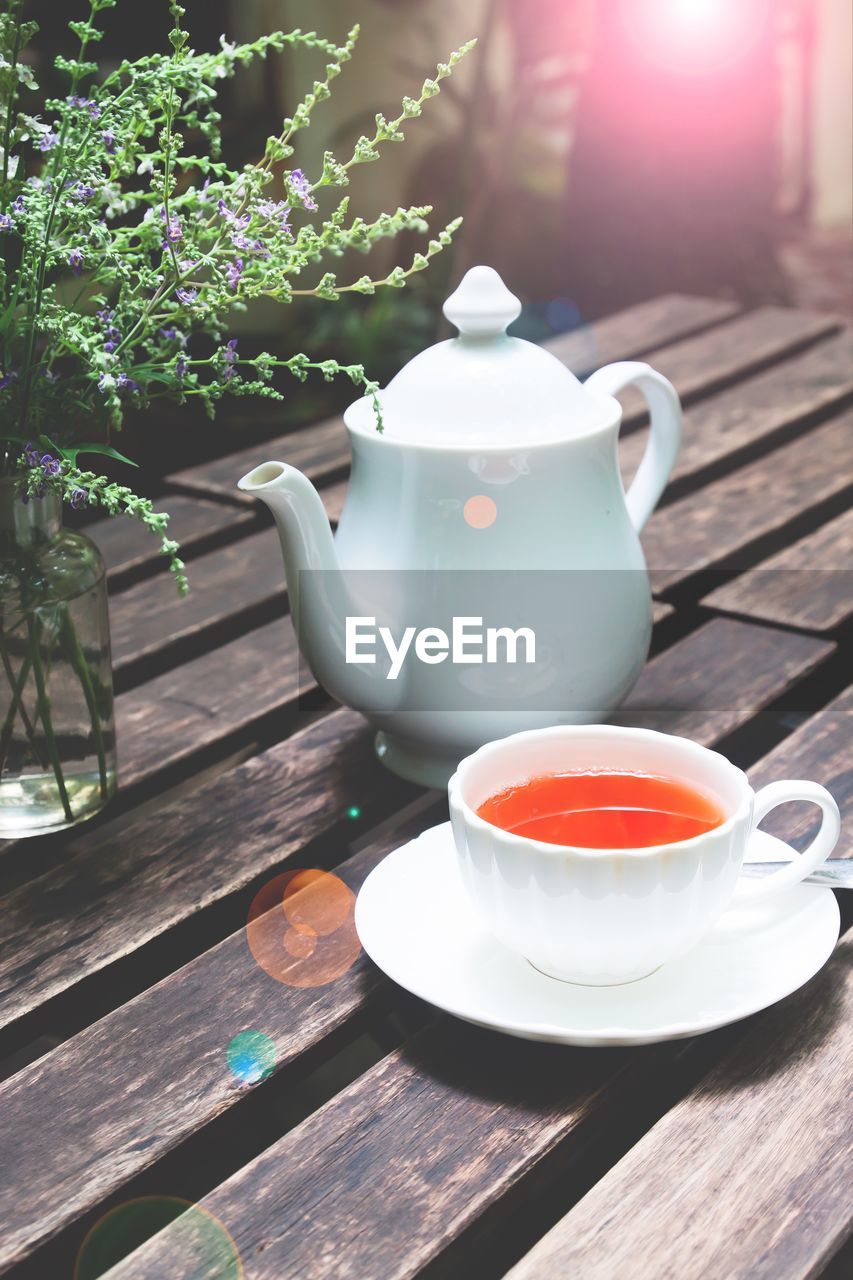 Close-up of tea cup and kettle on table