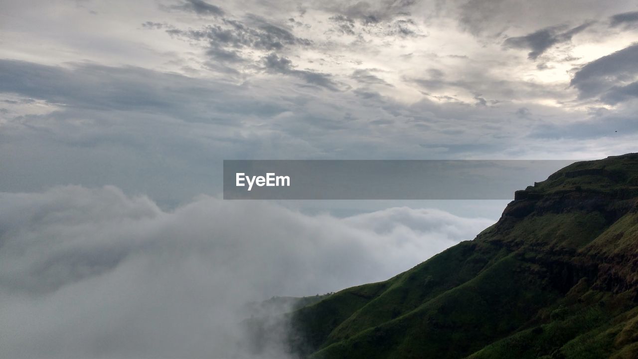 SCENIC VIEW OF CLOUDS OVER MOUNTAIN AGAINST SKY