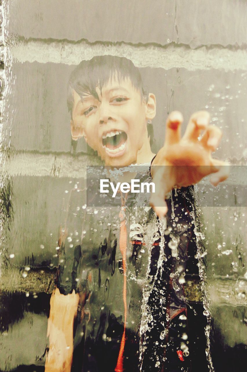 CLOSE-UP OF BOY PLAYING IN WATER AT PARK