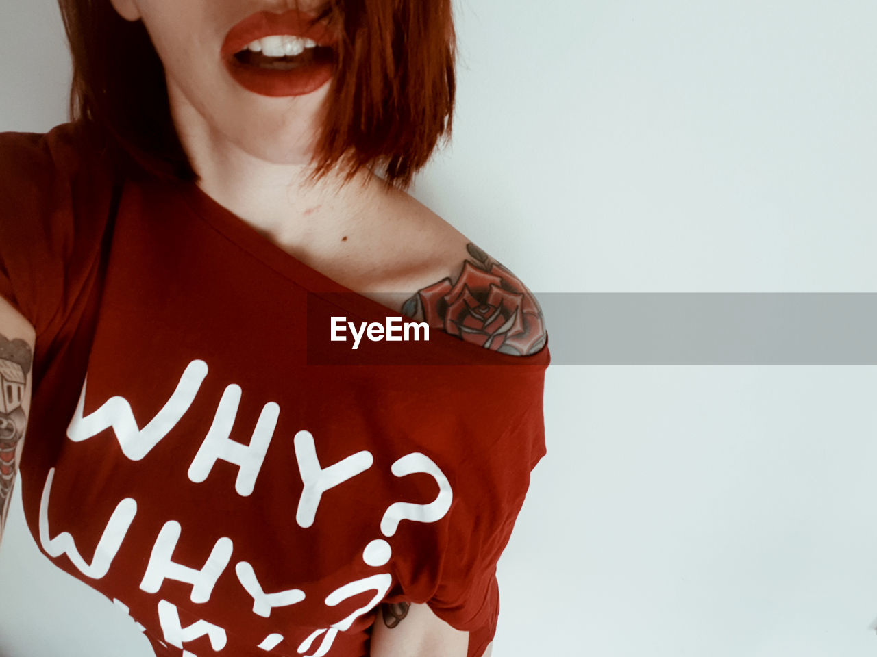 Midsection of woman with tattoo on shoulder against white background