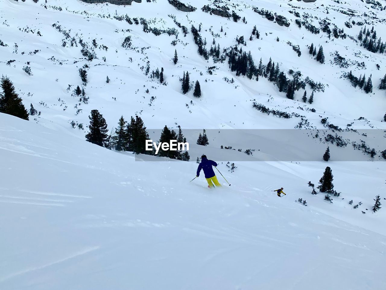 PEOPLE SKIING ON SNOWCAPPED MOUNTAINS