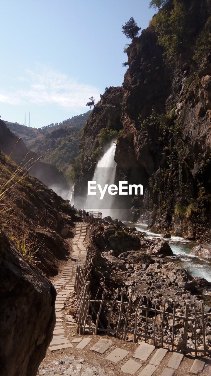 SCENIC VIEW OF WATERFALL AGAINST ROCKS