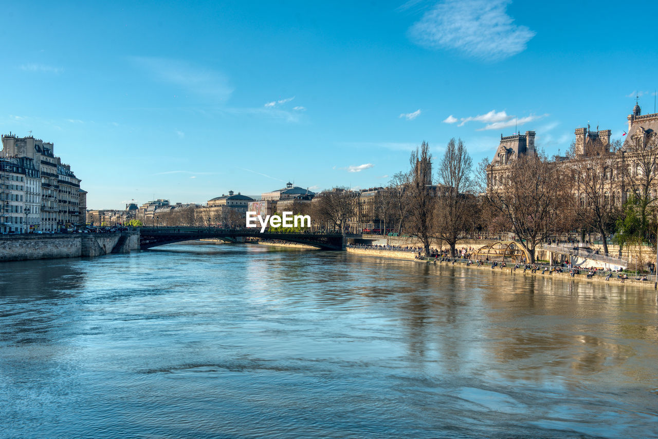 Arch bridge over river against buildings in city