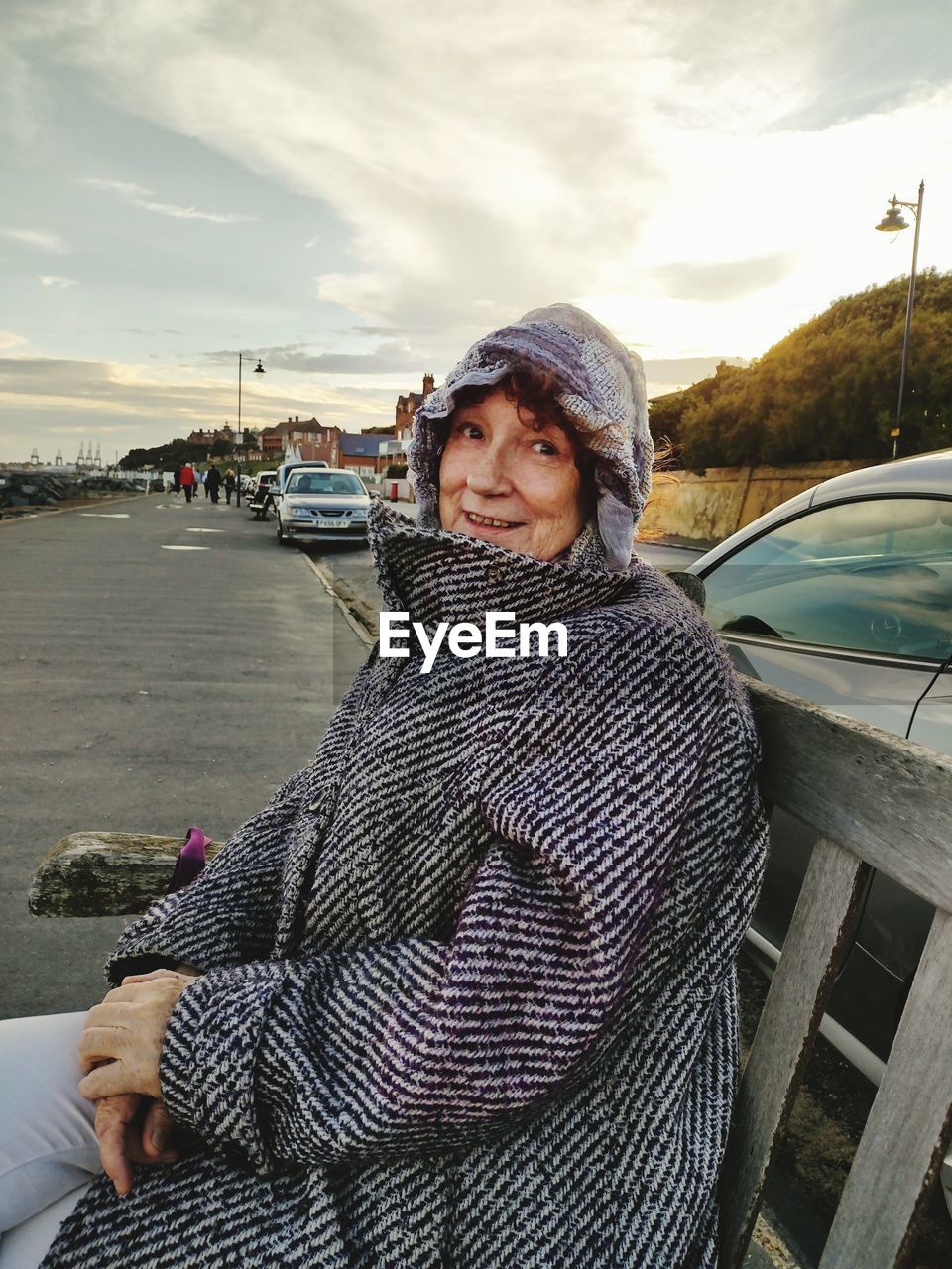 PORTRAIT OF WOMAN STANDING BY CAR ON ROAD AGAINST SKY